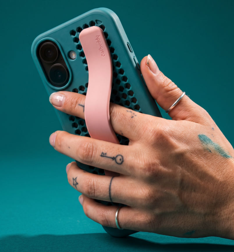 Hand holding the teal perforated phone case with pink strap