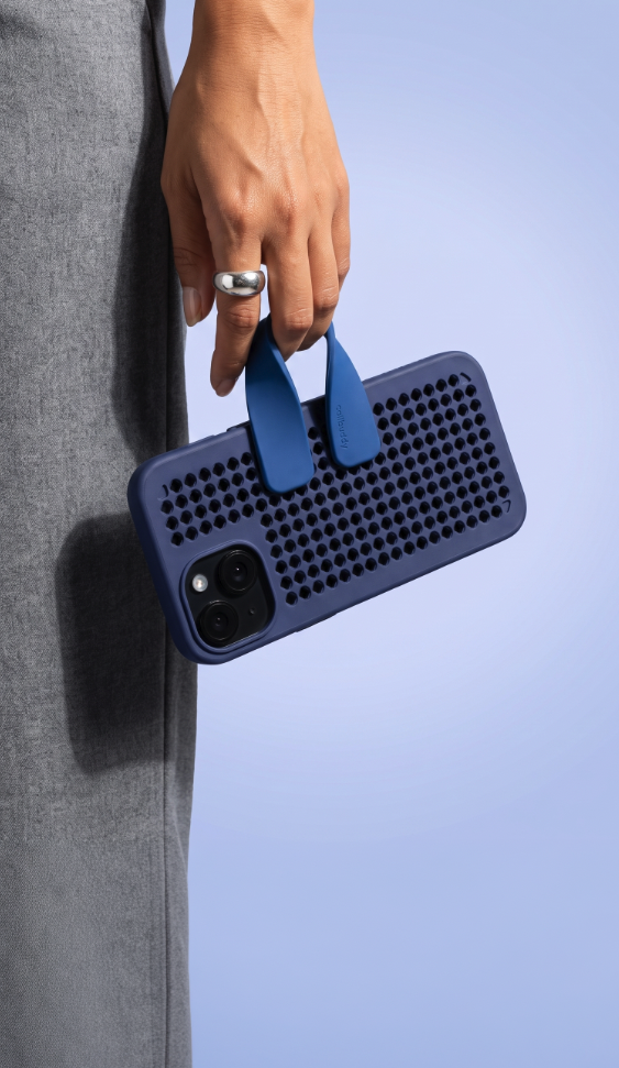Hand holding the navy perforated phone case with blue strap