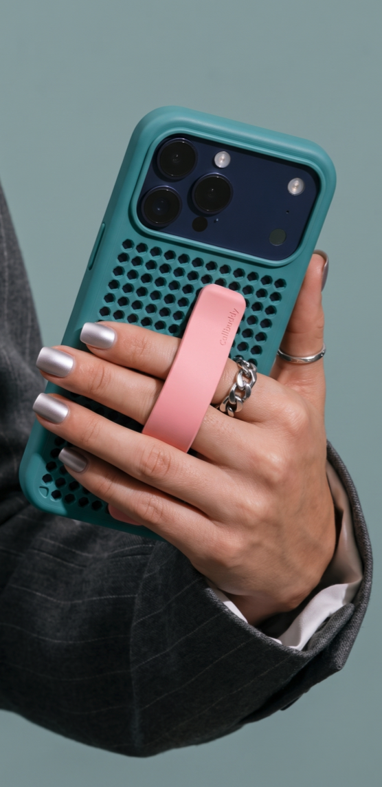 Hand in a pinstripe suit holding the teal perforated phone case with pink strap